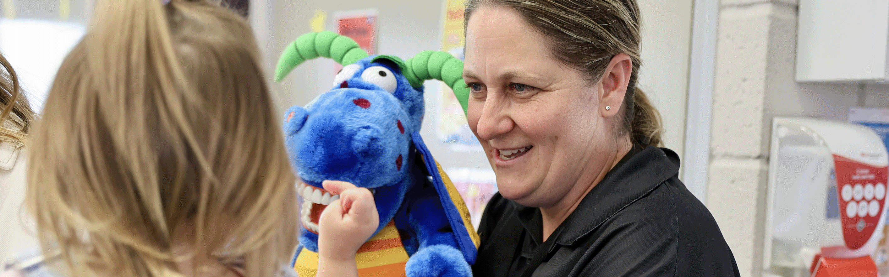 Staff member playing with blue puppet